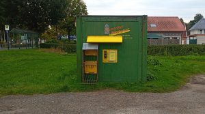 grüner Container mit gelber Aufschrift Kartoffelautomat